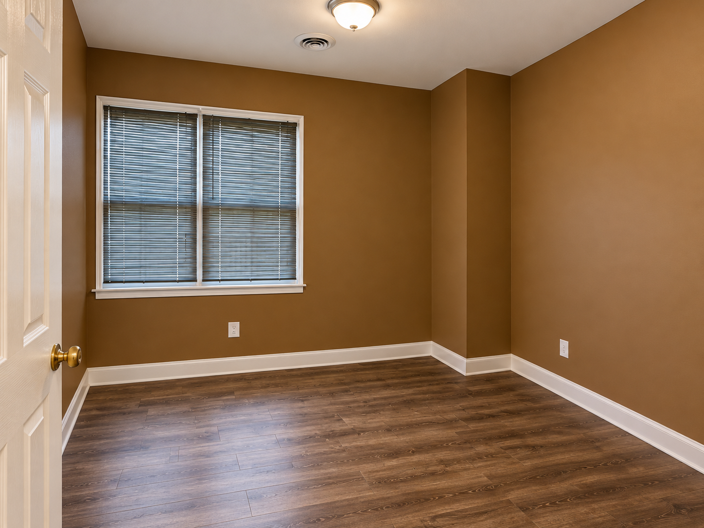 Finished basement room with white trim and wood-look flooring