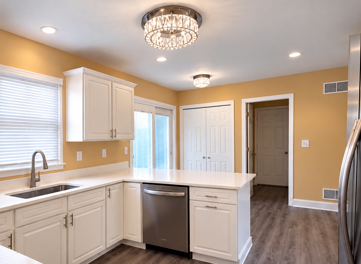 Renovated kitchen with cream cabinets and wood-look flooring
